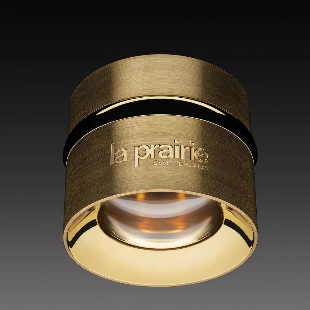 Vaso di crema dorata con fascia nera. "la prairie SWITZERLAND" è scritto sul davanti.