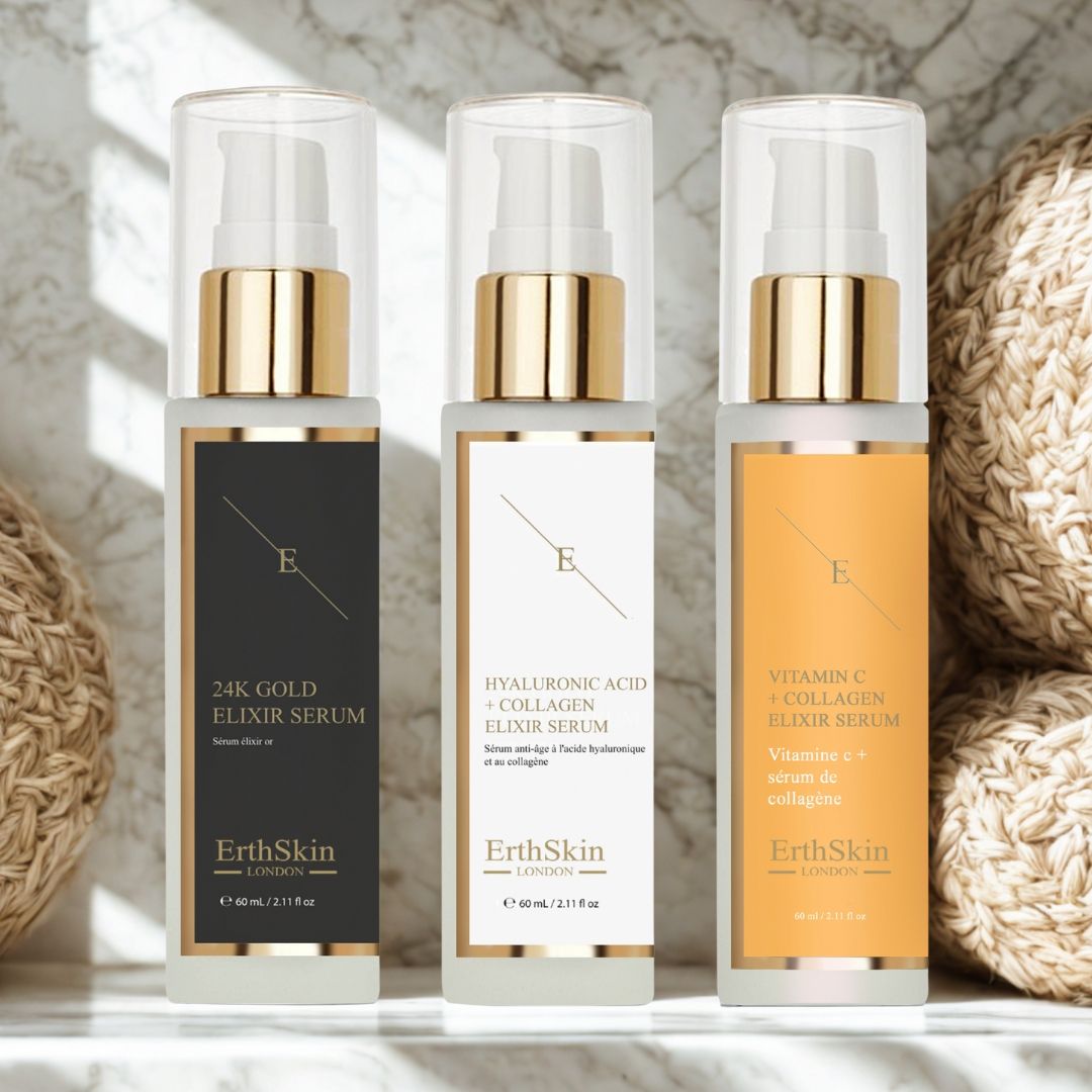 Tre flaconi di siero con tappi dorati ed etichette. Scritte: 24K Gold, Acido Ialuronico + Collagene, Vitamina C + Collagene. Marchio: ErthSkin London.