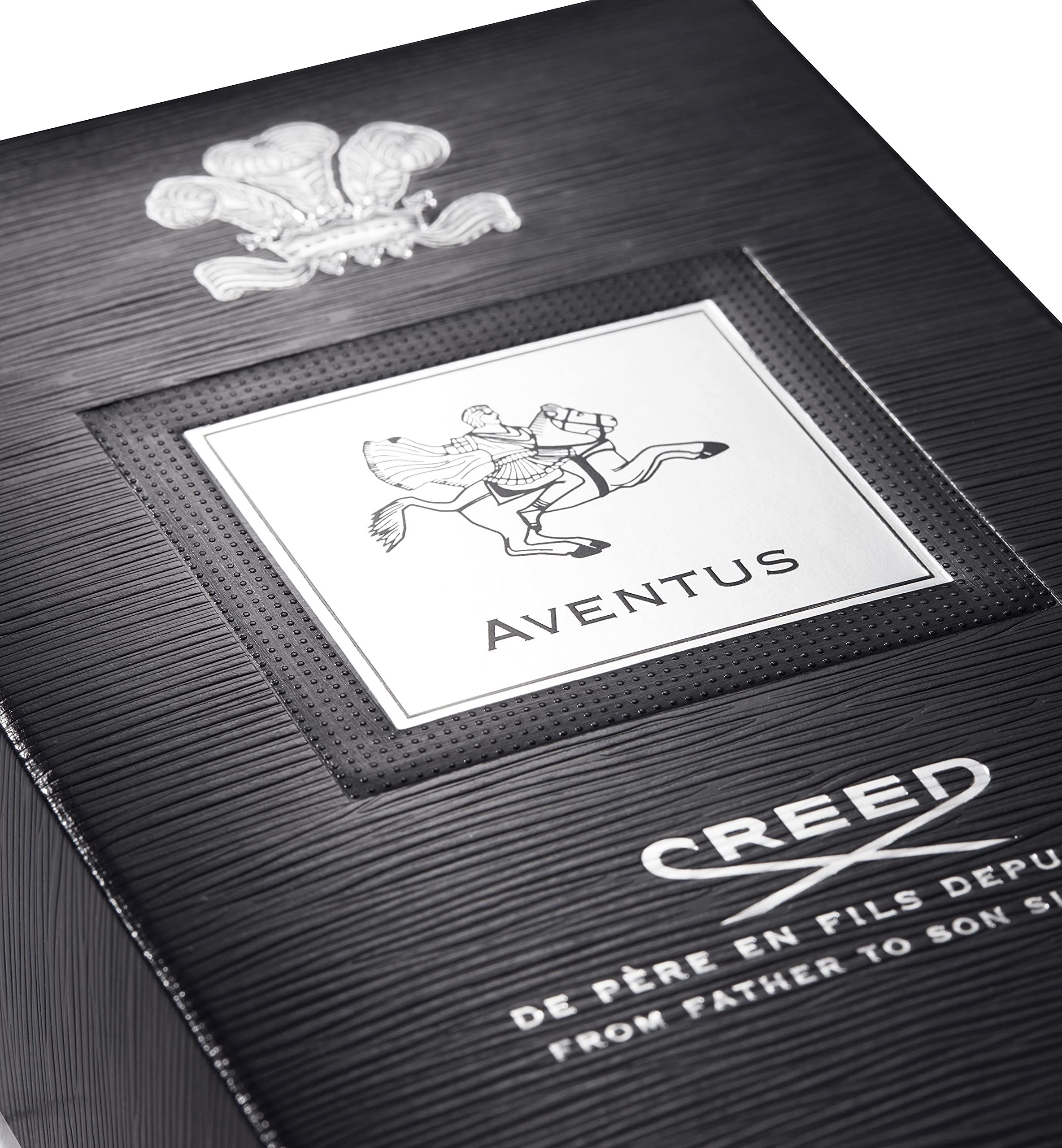 Confezione nera con logo e scritta argentati. In alto è raffigurato uno stemma. Il testo è: Aventus, Creed.
