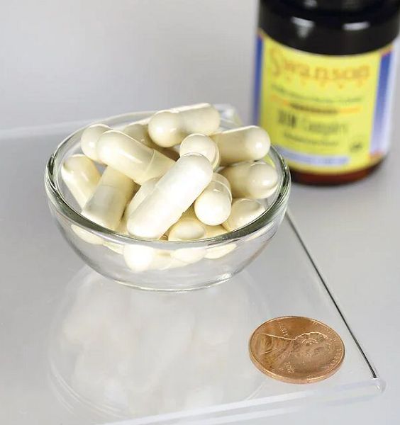 Ciotola trasparente con capsule bianche. Accanto, una moneta e un flacone con etichetta gialla.