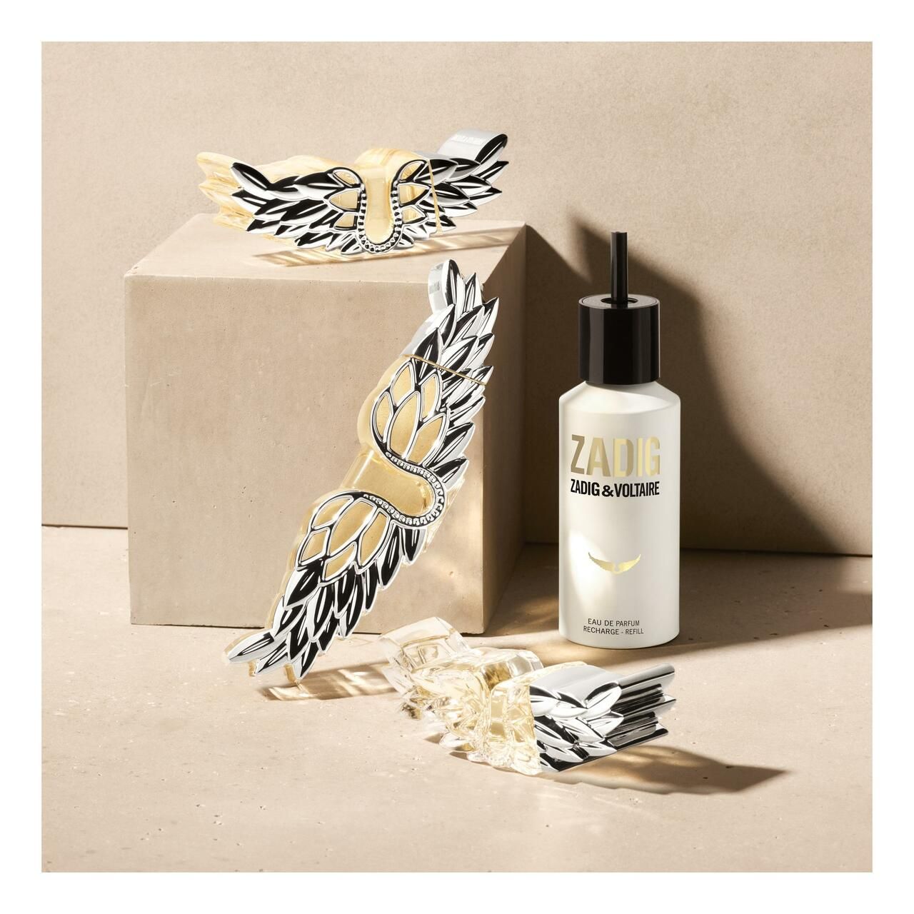 Flacone Zadig & Voltaire con decorazioni ad ali. Posizionato su un cubo, con confezione.