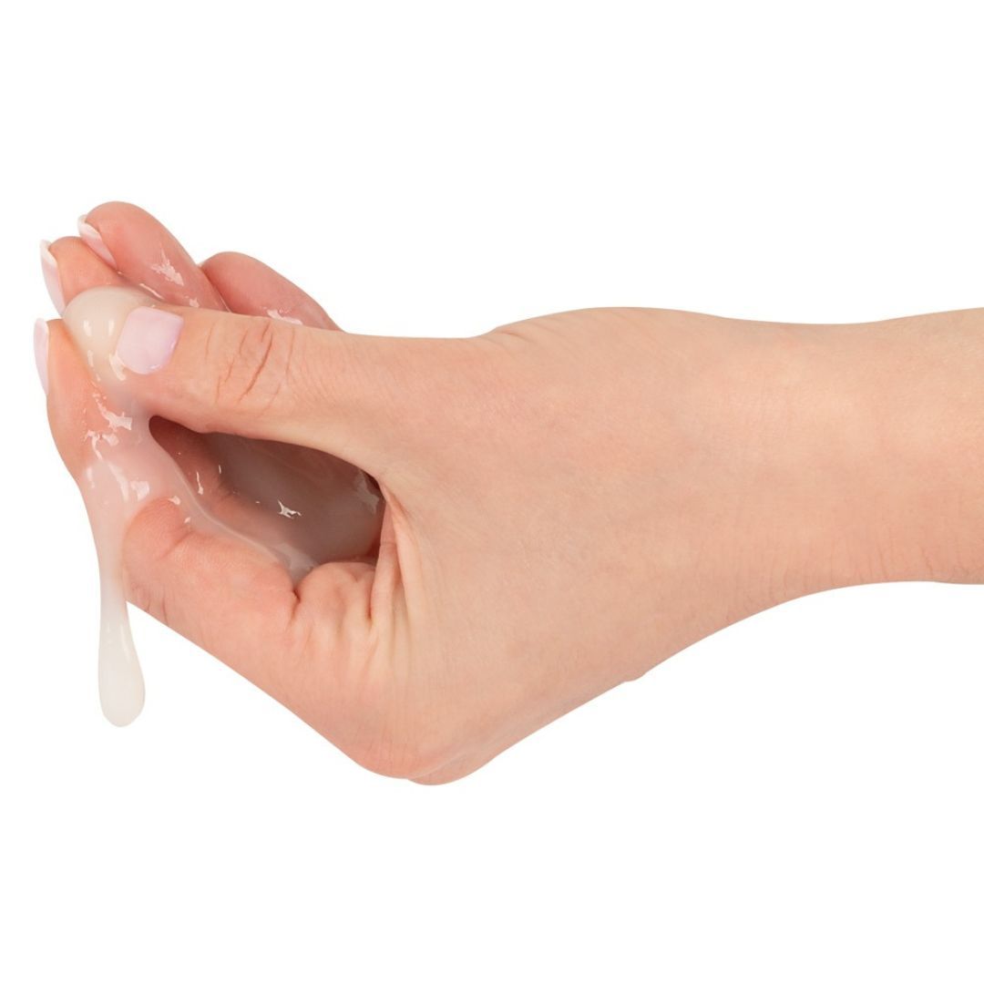 Mano con sostanza cremosa bianca. Liquido che gocciola dalla mano.