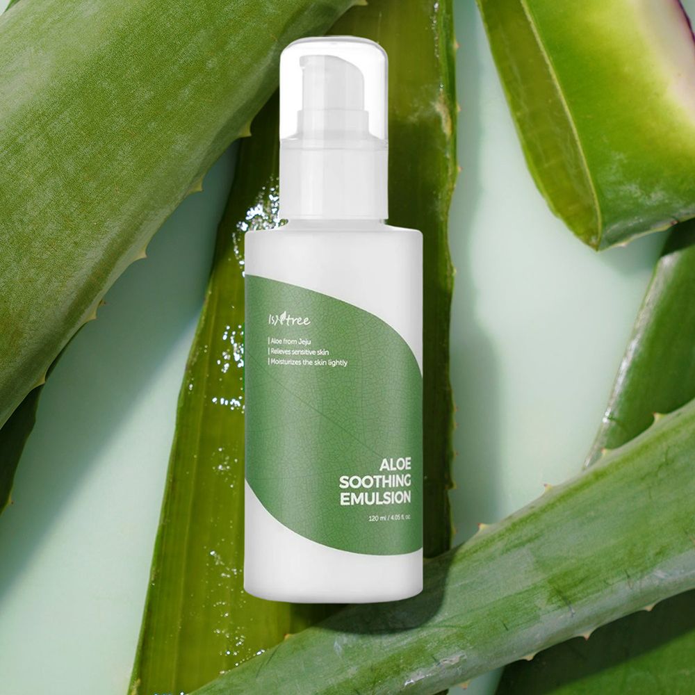 Flacone bianco con etichetta verde. Testo: Aloe Soothing Emulsion. Sfondo: foglie di aloe vera.