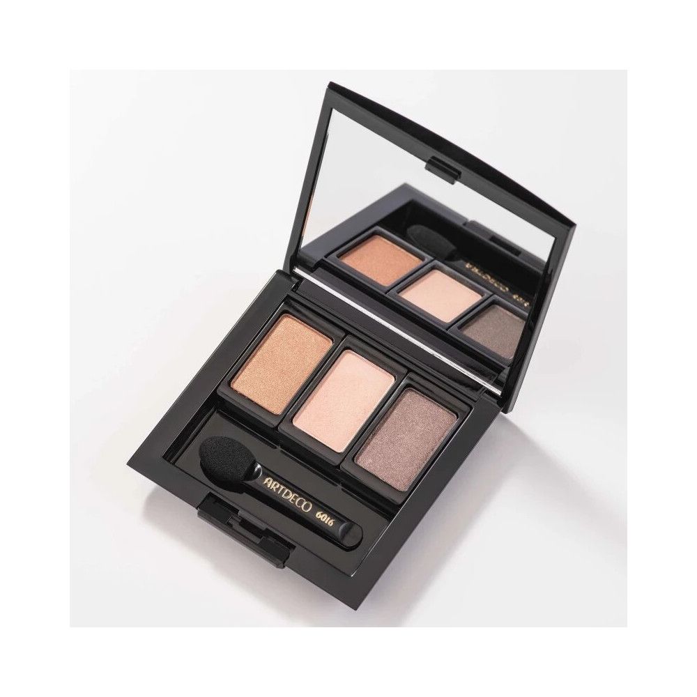 Palette cosmetica nera con specchio e tre ombretti. Un applicatore è accanto. Sul manico è scritto ARTDECO 6016.