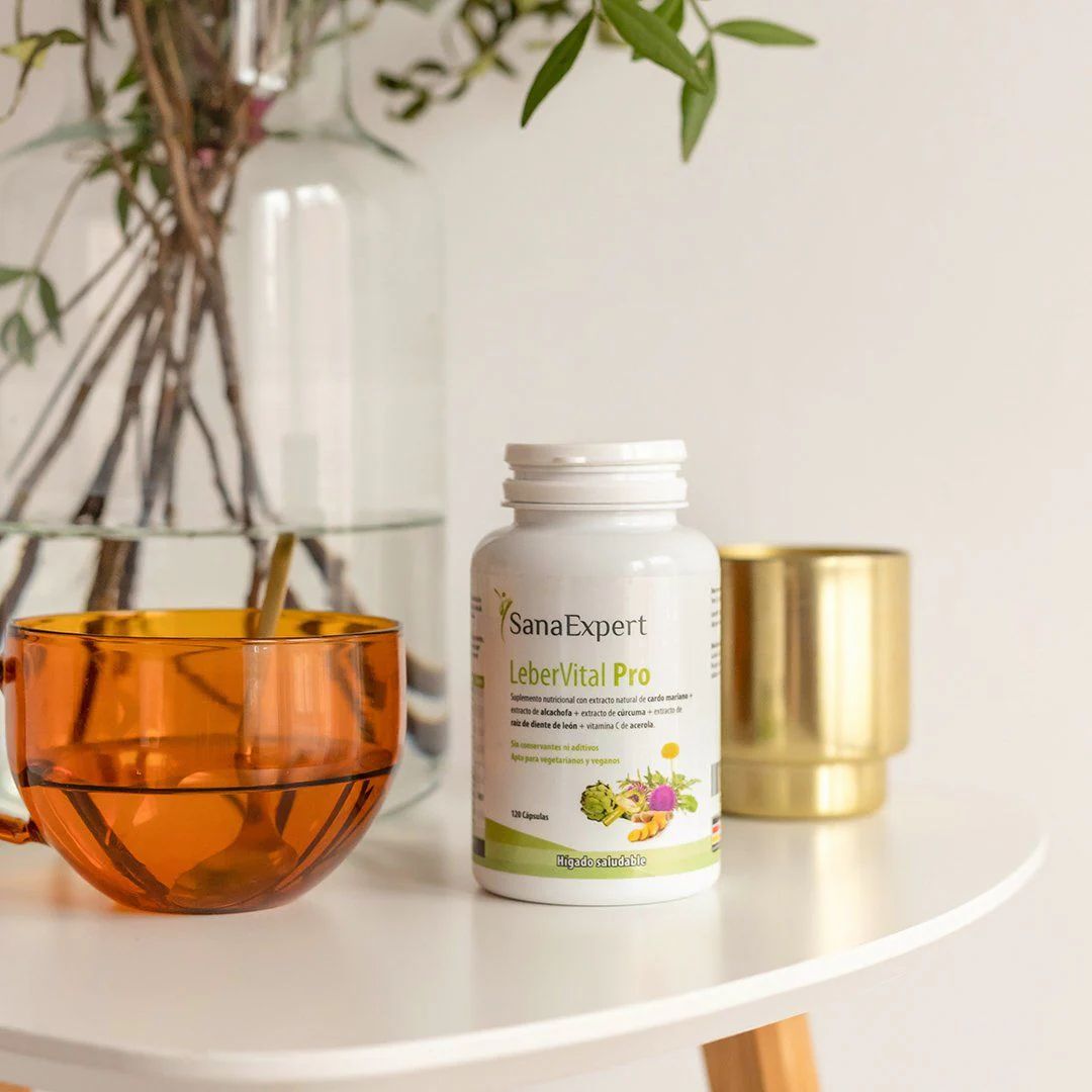 Bottiglia bianca SanaExpert LeberVital Pro su un tavolo. Accanto, una tazza e una ciotola dorata.