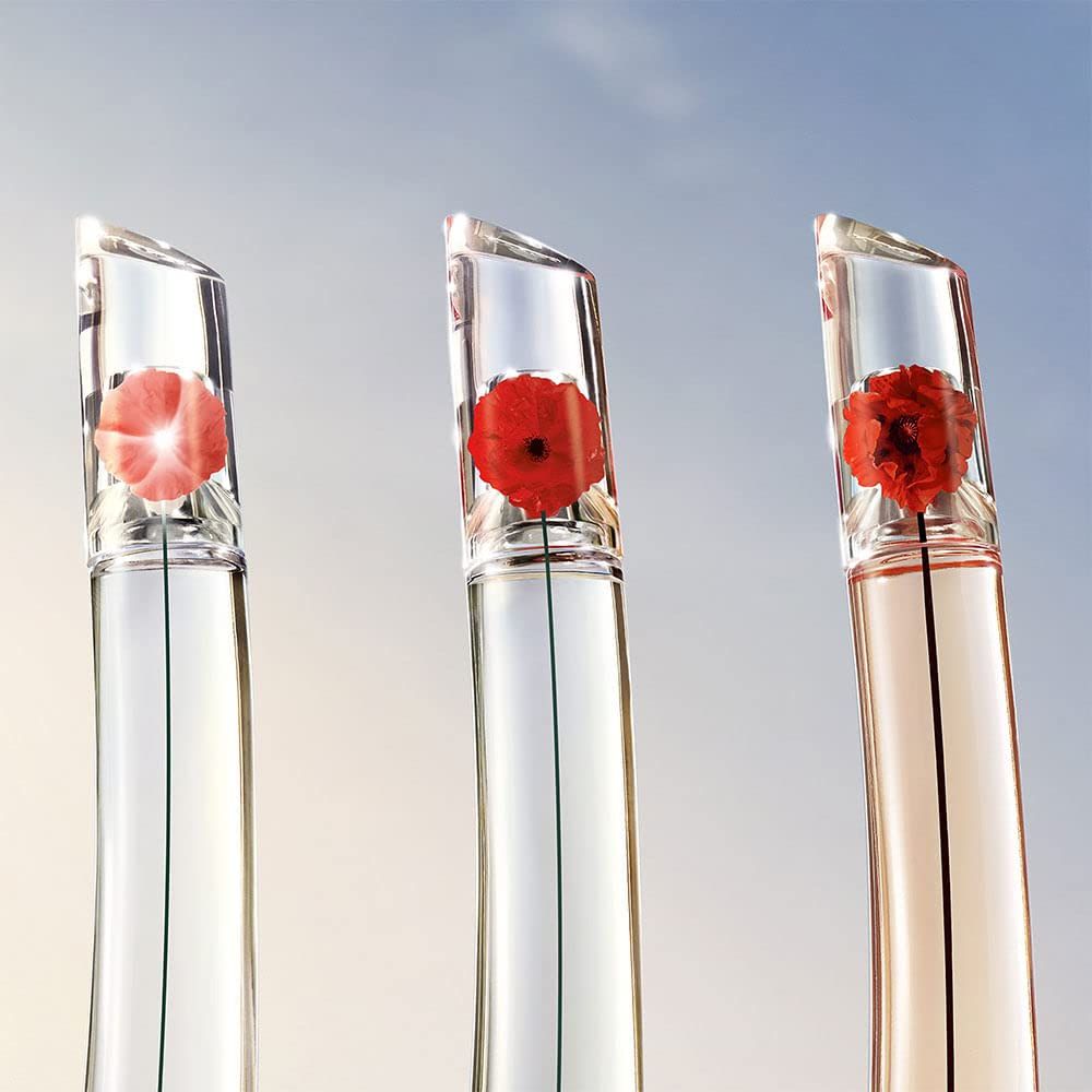 Tre flaconi con fiori nel tappo. Diversi colori del liquido.