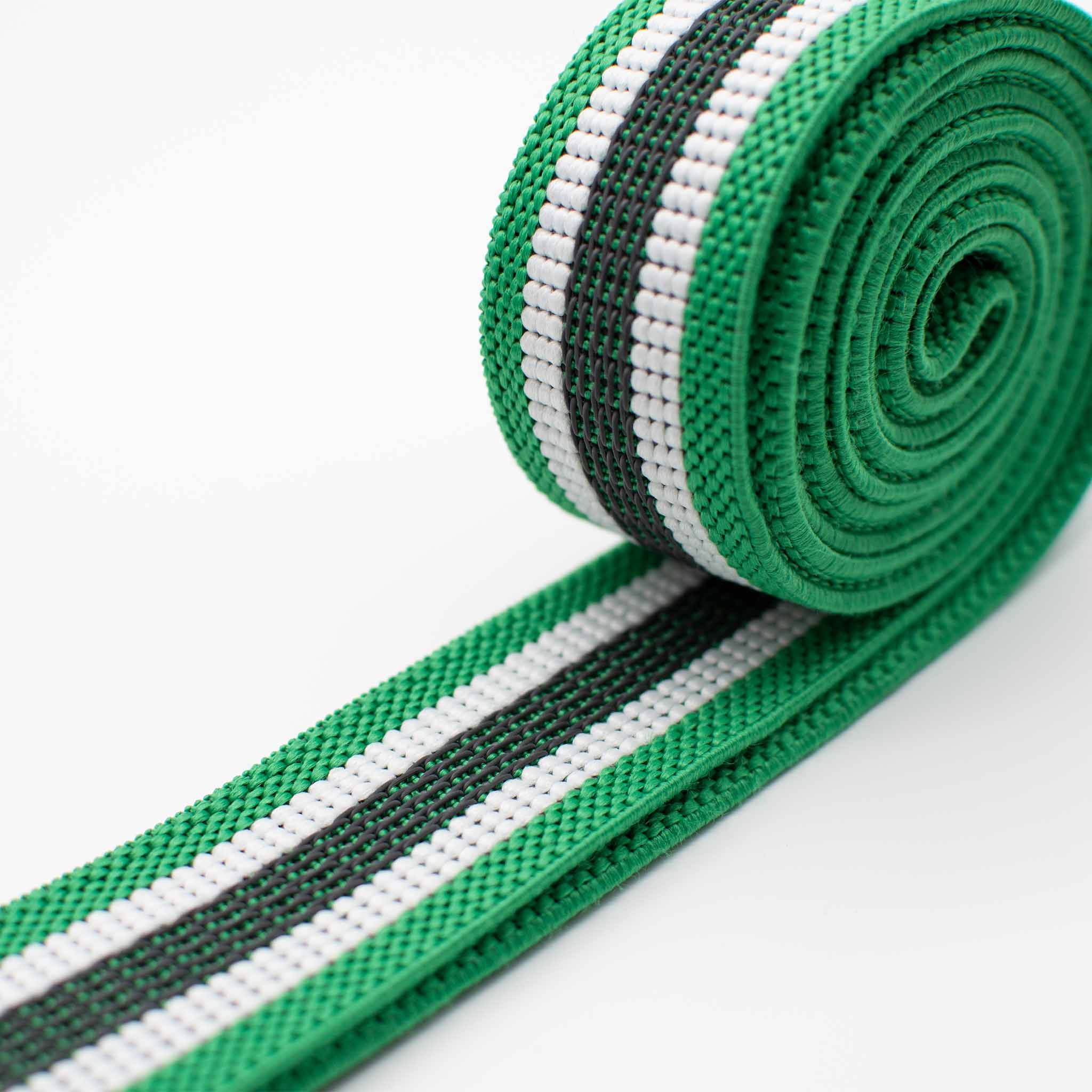 Fascia di resistenza in tessuto verde con strisce bianche e nere. Arrotolata, mostra la larghezza e il materiale.
