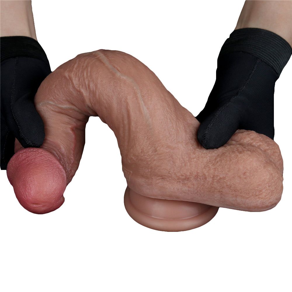 Dildo marrone, tenuto in mano con guanti neri. Texture e forma realistiche.