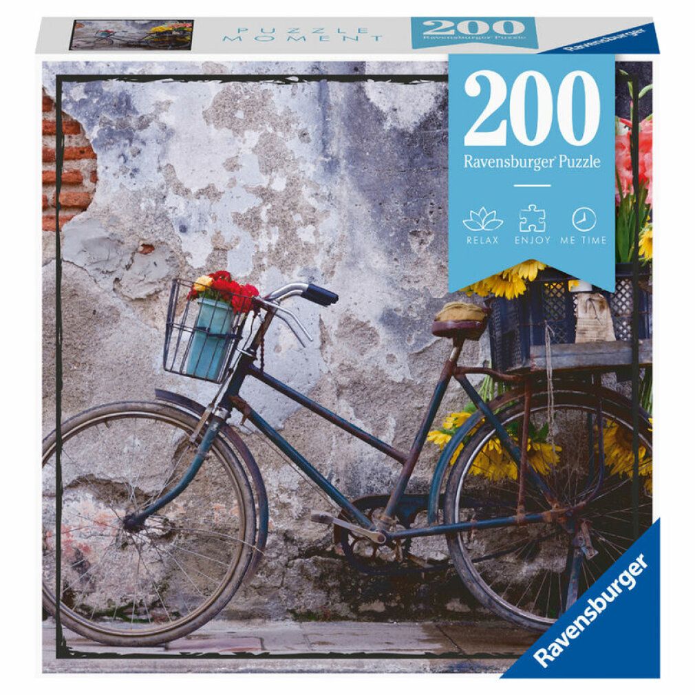 Puzzle da 200 pezzi. Soggetto: bicicletta con fiori davanti a un muro. Marca: Ravensburger. Confezione: quadrata.