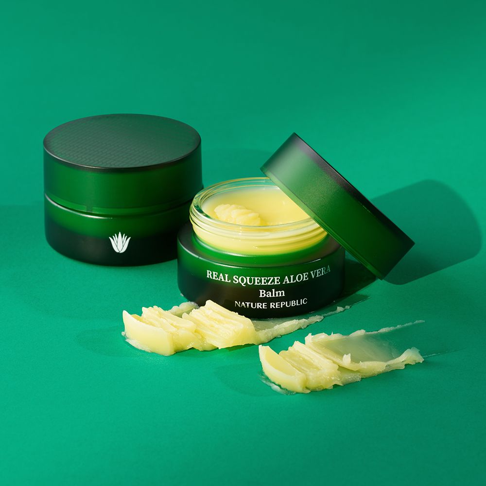 Due vasetti verdi con balsamo giallo e strisce. Scritta: Real Squeeze Aloe Vera Balm.