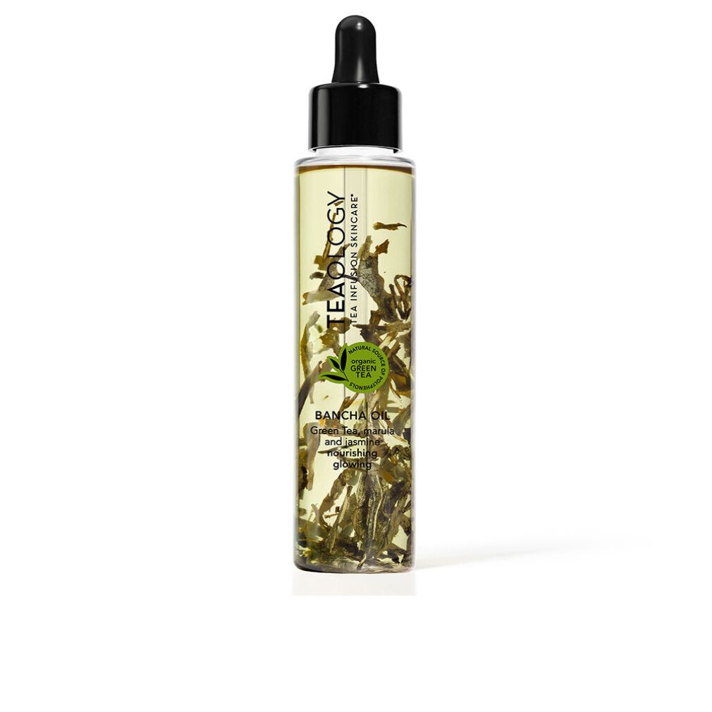 Olio corpo al tè verde. Flacone trasparente con tappo nero. Tè verde visibile. Nome del prodotto visibile.