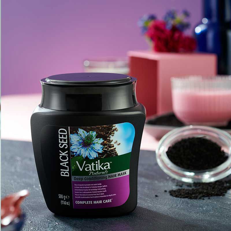 Maschera per capelli nera con etichetta. Scritta: Vatika Naturals, Deep Conditioning Hair Mask. Illustrazione di semi di cumino nero. 500g.
