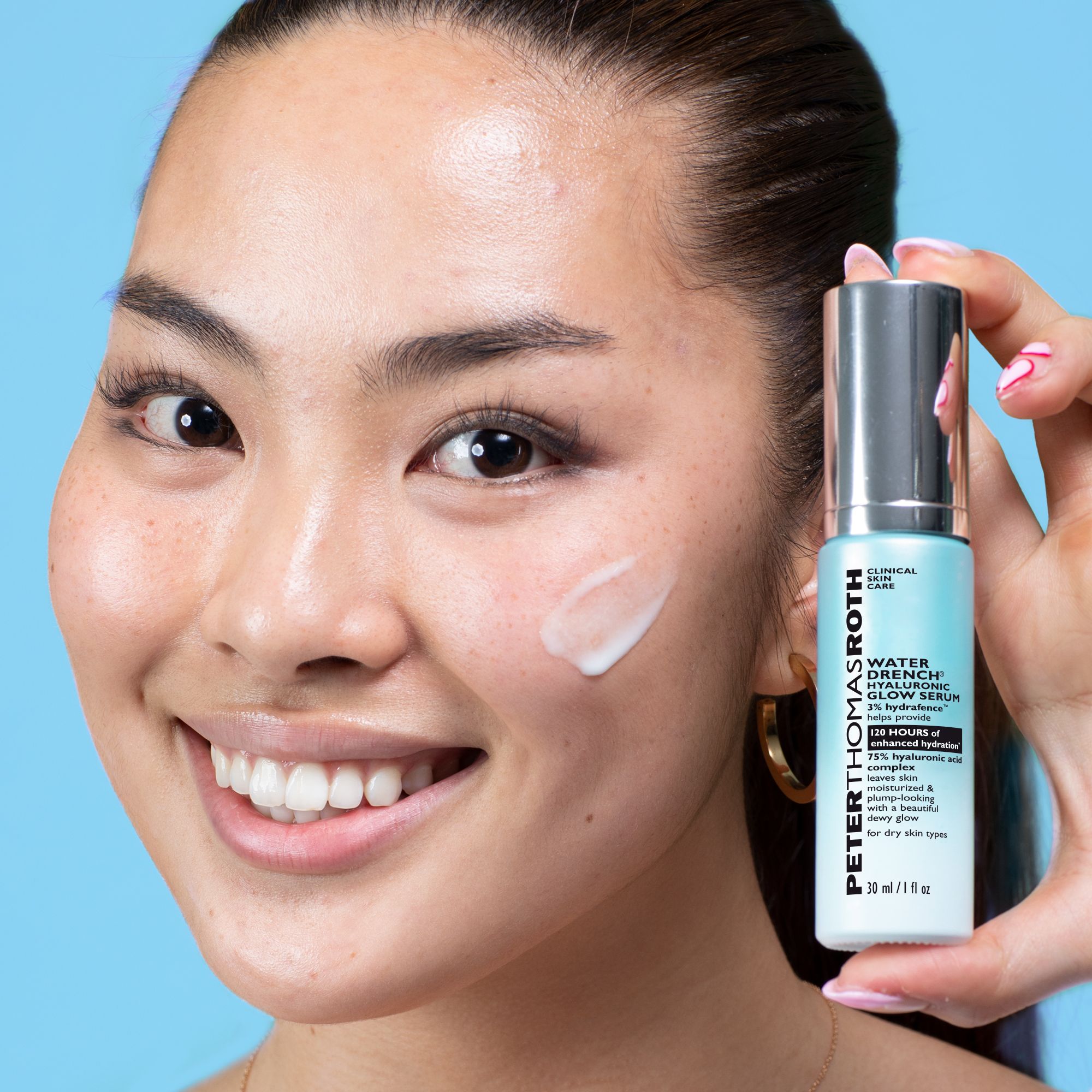 Donna che tiene in mano un flacone di siero. Scritta: Peter Thomas Roth Water Drench® Hyaluronic Glow Serum. Siero applicato sul viso.