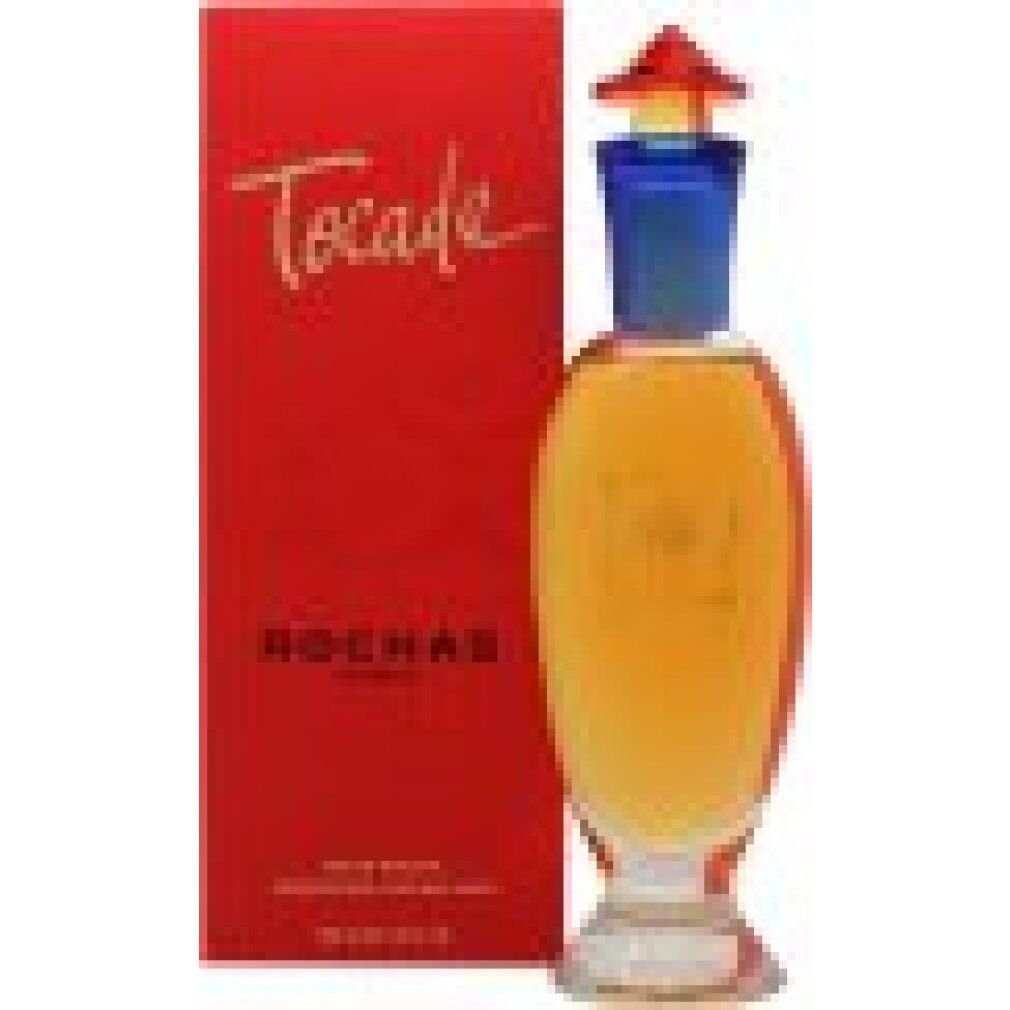 Confezione rossa e flacone in vetro. Scritta dorata "Tocade" sulla confezione. Flacone con liquido giallo, collo blu e tappo rosso.