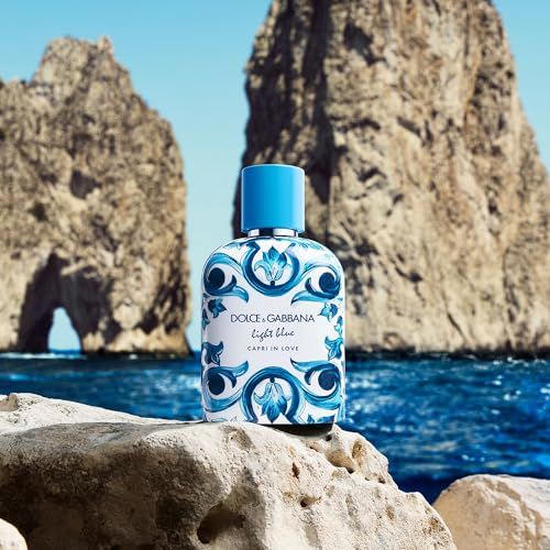 Flacone di profumo con tappo blu e decoro su pietra. Sfondo: rocce e mare. Scritta: Dolce & Gabbana.