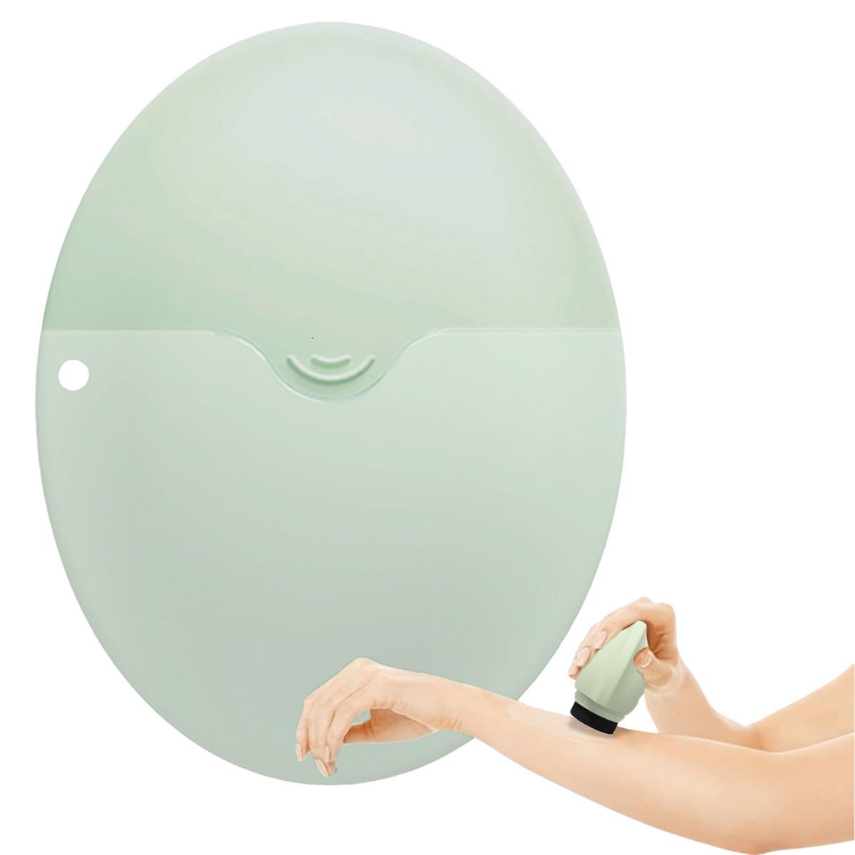 Applicatore verde chiaro in uso. Una mano tiene l'applicatore, l'altra lo strofina sul braccio. Il prodotto è in silicone.