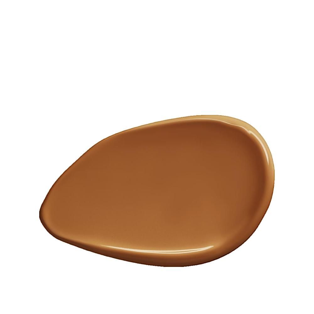 Macchia di fondotinta color pelle. La texture è liscia e lucida. Il colore è una tonalità di marrone caldo e scuro.