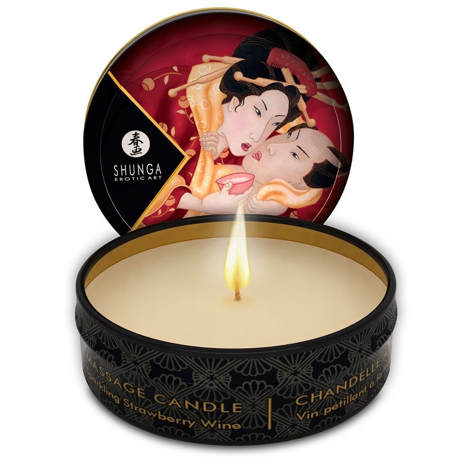 Candela da massaggio accesa in scatola nera con motivo erotico e scritta 'Massage Candle Sparkling Strawberry Wine'.