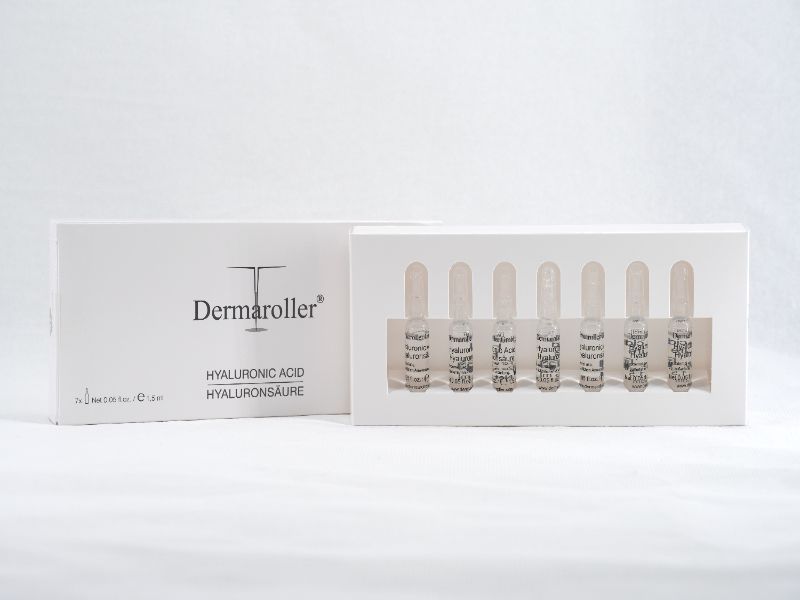 Dermaroller Hyaluron-Ampullen 7er Riegel: Sei piccole fiale di vetro con acido ialuronico in una confezione bianca.