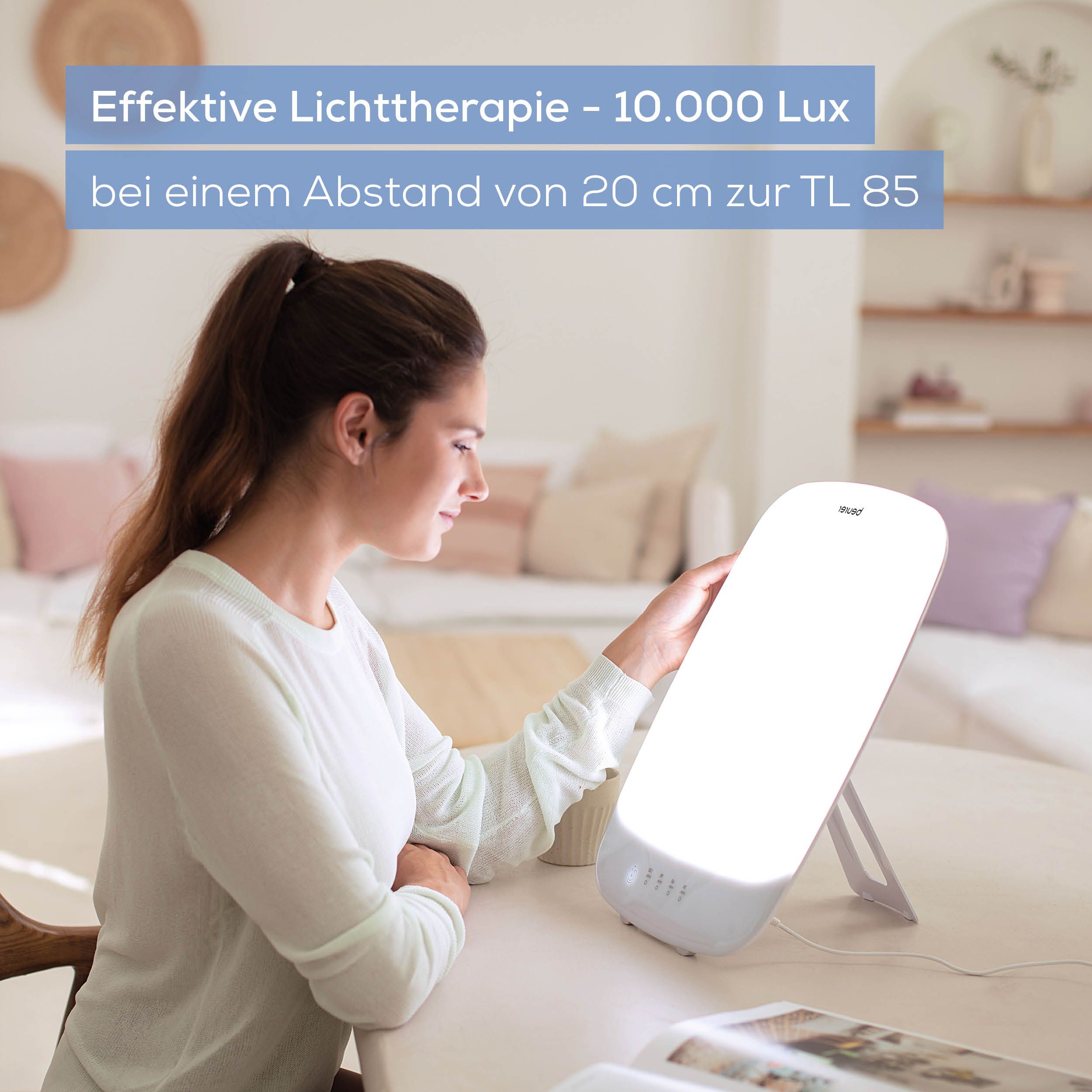 Donna che utilizza la lampada per la luce. Testo: Terapia della luce efficace - 10.000 Lux.
