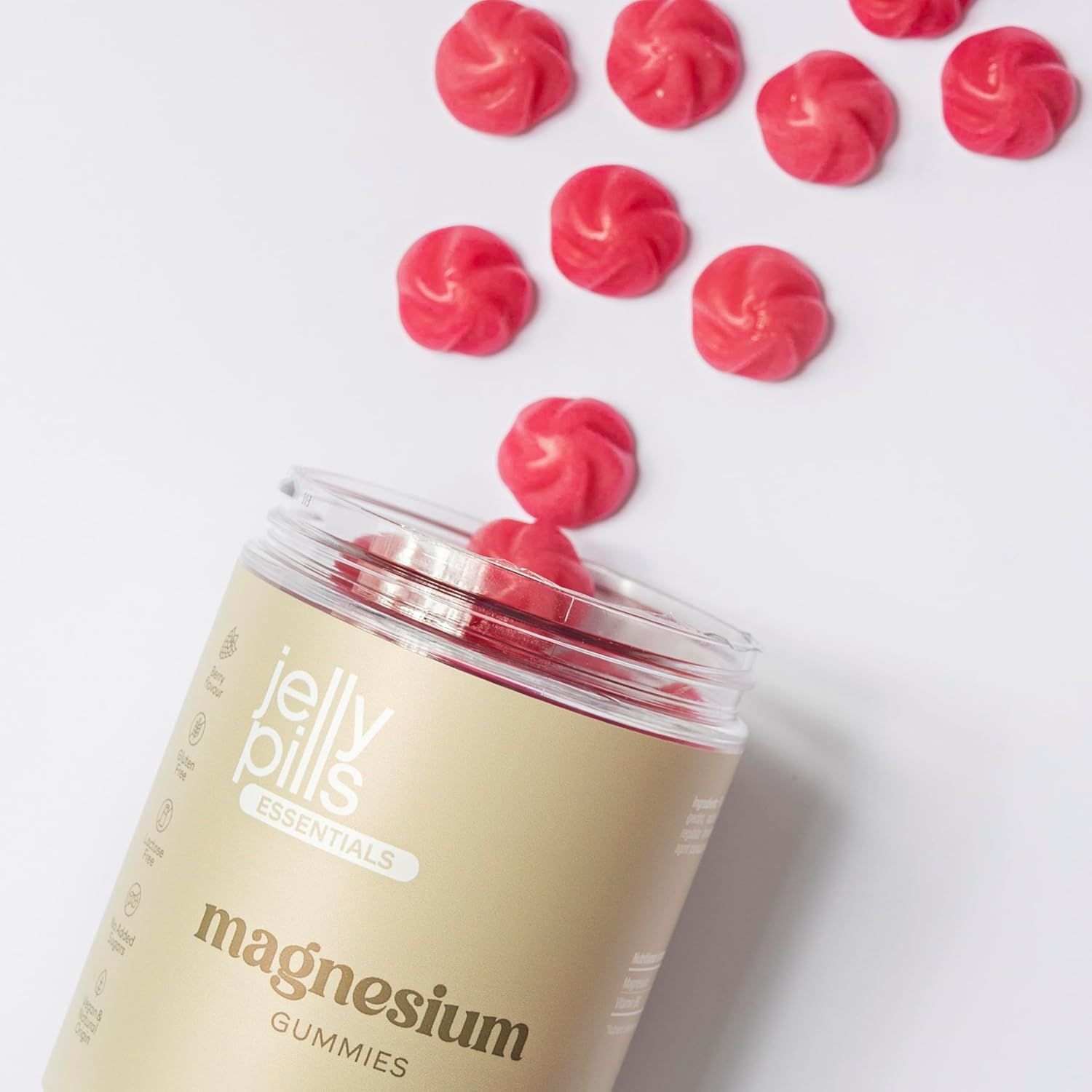 Barattolo aperto di Jelly Pills Magnesium Gummibärchen. Caramelle rosse che cadono.