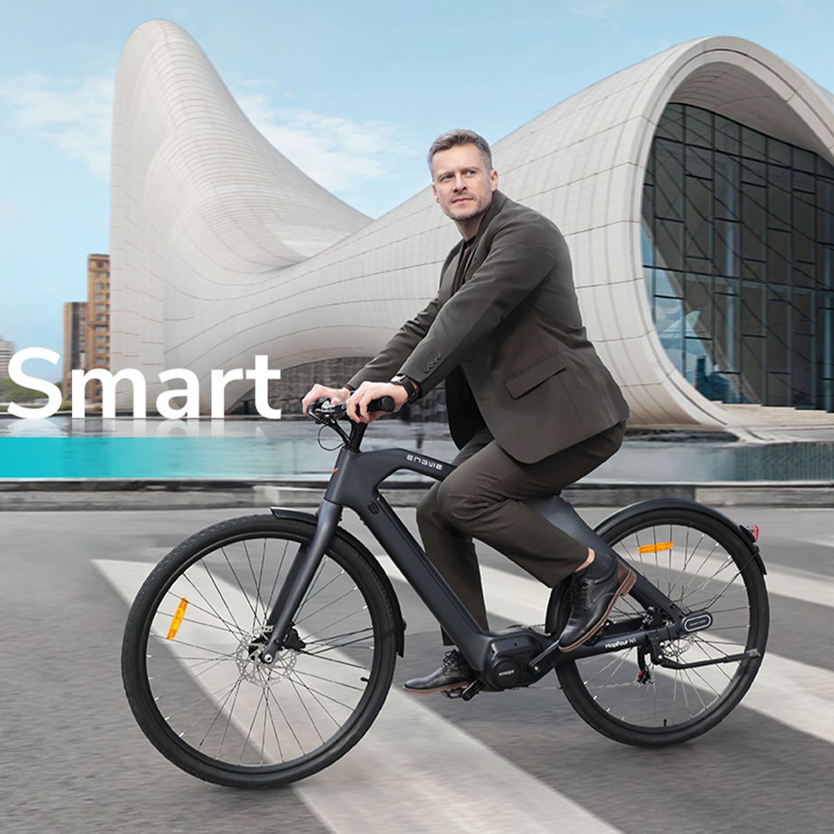 Uomo in sella a una bicicletta elettrica grigio scuro. Edificio sullo sfondo. Logo Engwe visibile.