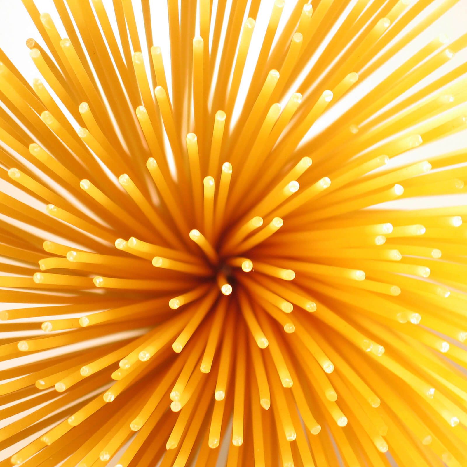 Spaghetti, vista dall'alto. Lunghe paste gialle che si irradiano dal centro.