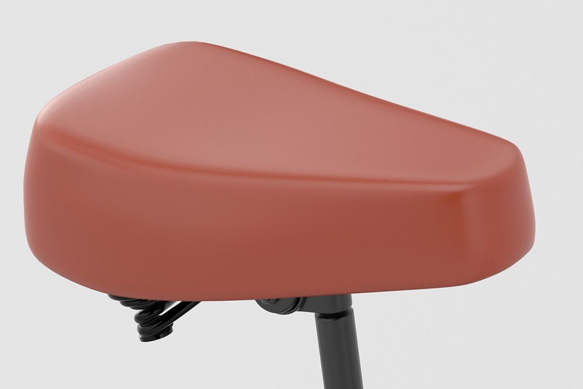 Sella per bicicletta marrone. Supporto nero. Sospensione visibile. Primo piano.