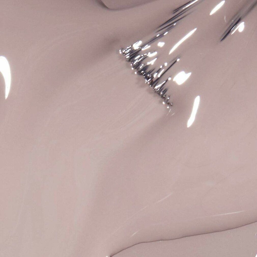 Primo piano di smalto per unghie. Tonalità beige. Pennello con smalto. Superficie lucida.