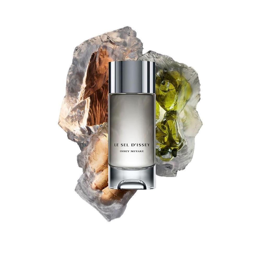 Flacone LE SEL D'ISSEY, ISSEY MIYAKE, su pietre ed elementi verdi. Tappo argentato, base trasparente.