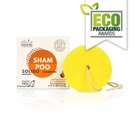 Shampoo solido giallo con cordino e confezione. Scritta: SHAMPOO SOLIDO, RINFORZANTE E ILLUMINANTE. Certificazione: ECO PACKAGING AWARDS.
