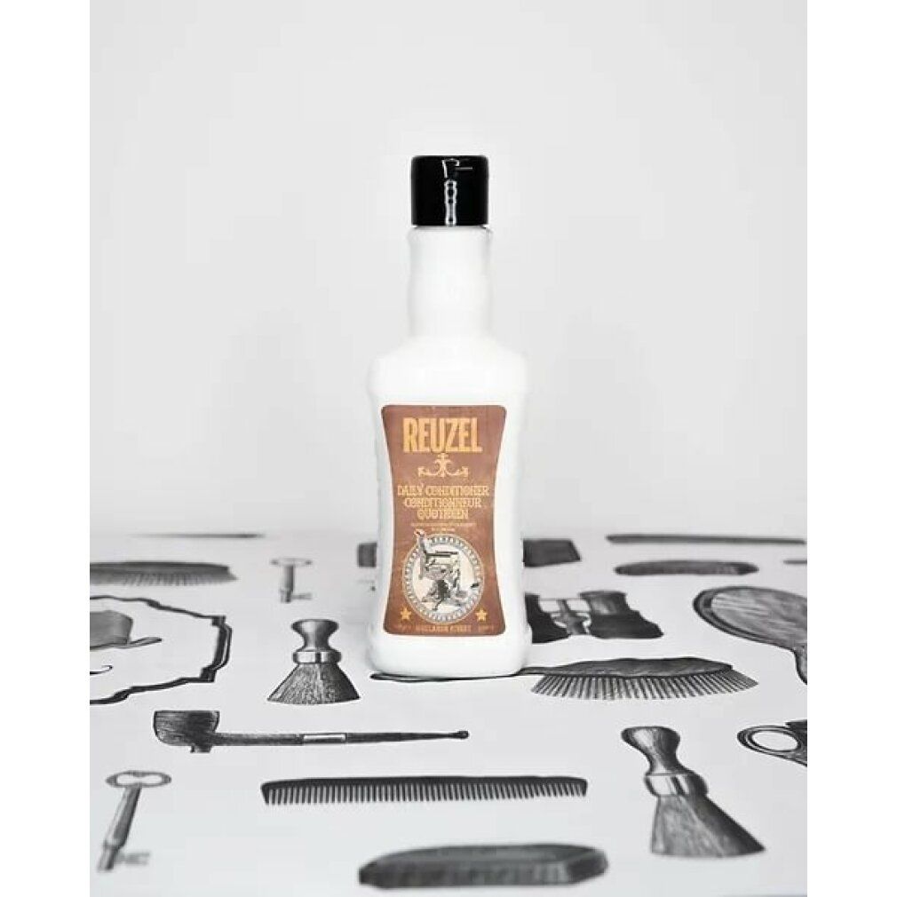 Flacone di Reuzel Daily Conditioner su sfondo a motivi. Prodotto bianco con etichetta marrone e tappo nero. Testo: Daily Conditioner.