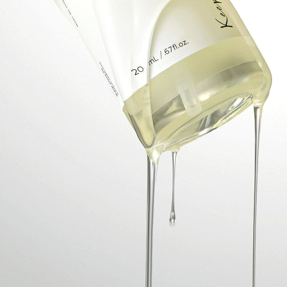 Liquido trasparente che cola da un flacone trasparente. Scritta: 20 ml / 0.67 fl.oz.