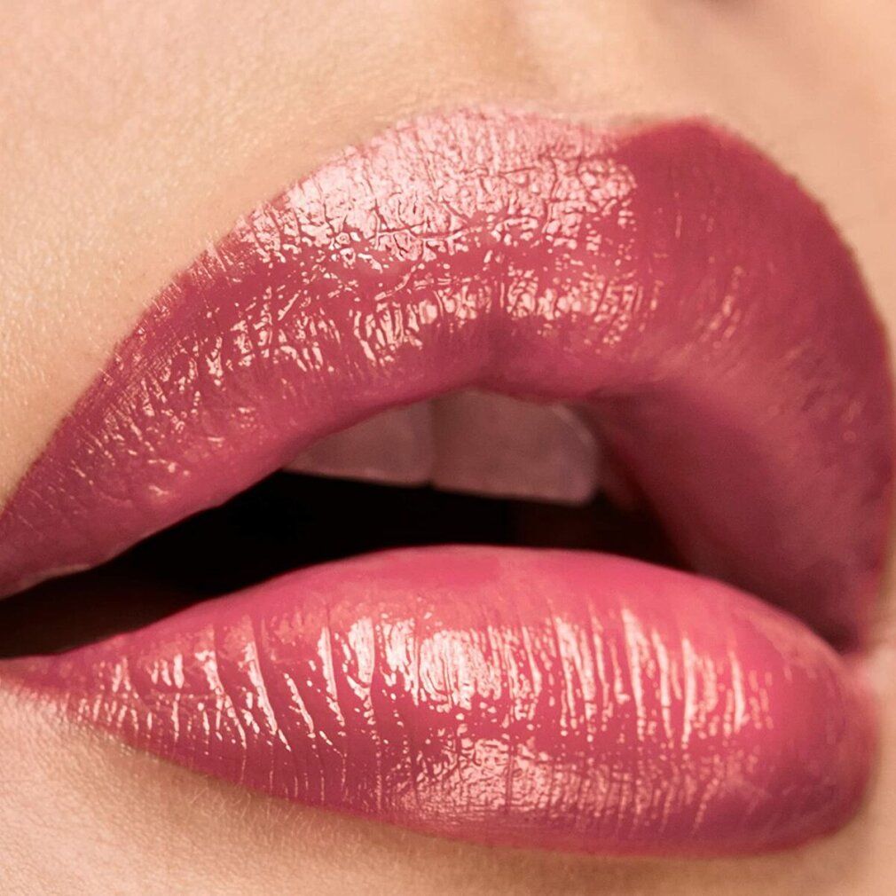 Primo piano di labbra truccate con rossetto rosa lucido.