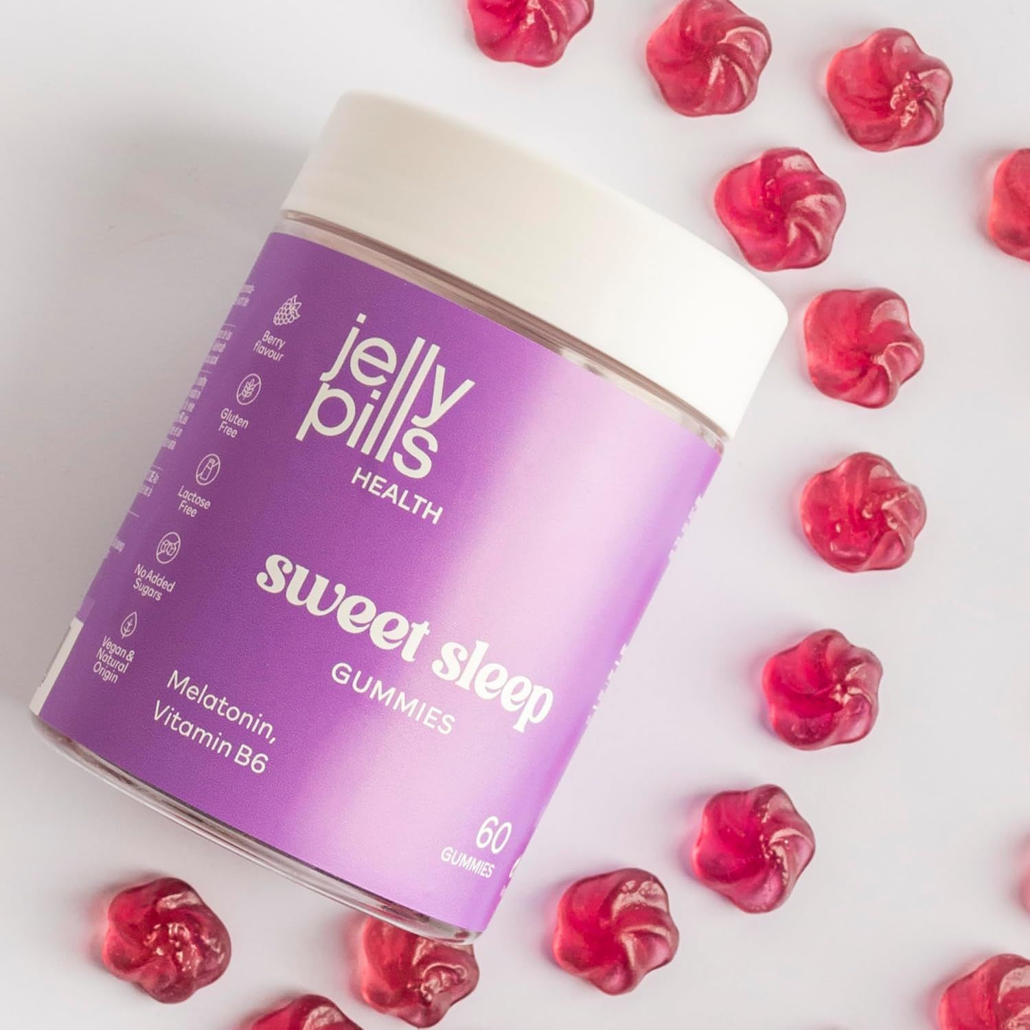 Jelly Pills Sweet Sleep Gummies. Barattolo viola con 60 caramelle gommose. Caramelle rosse sparse. Contiene melatonina e vitamina B6.