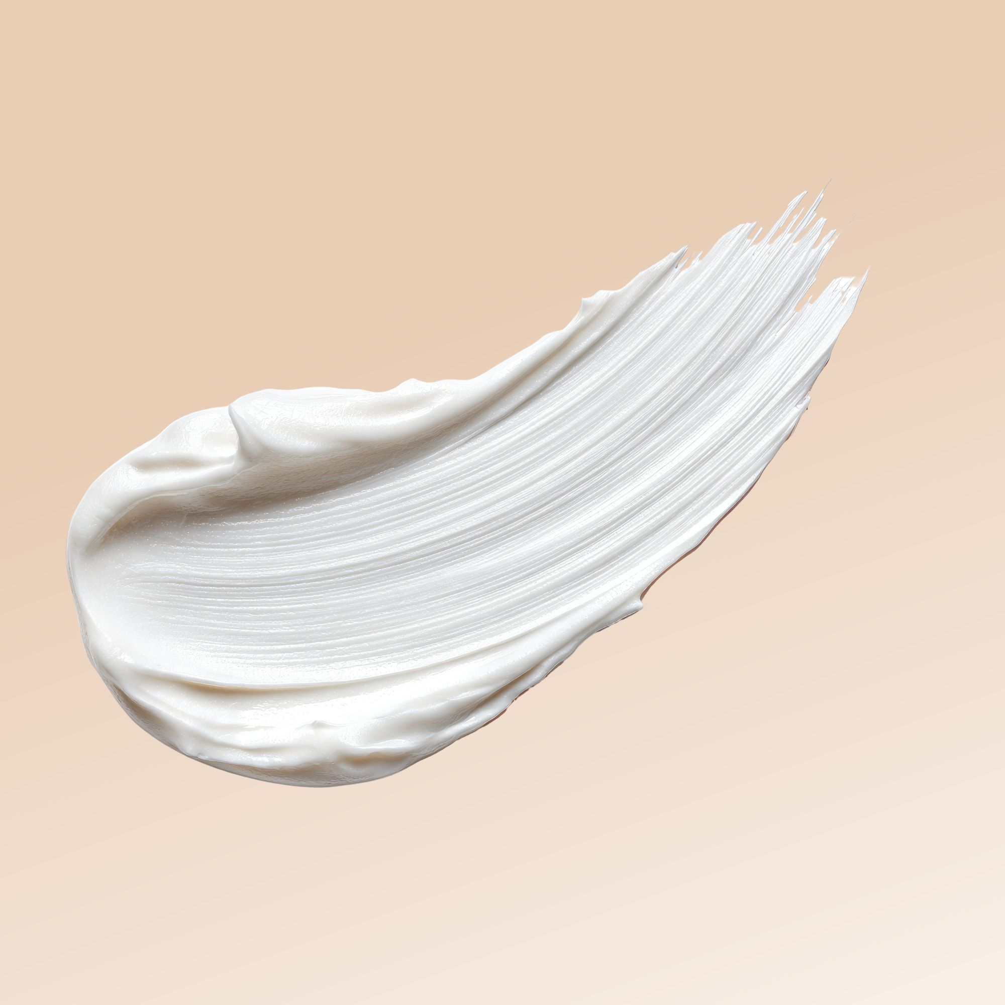 Traccia di crema bianca su sfondo beige. Texture visibile.
