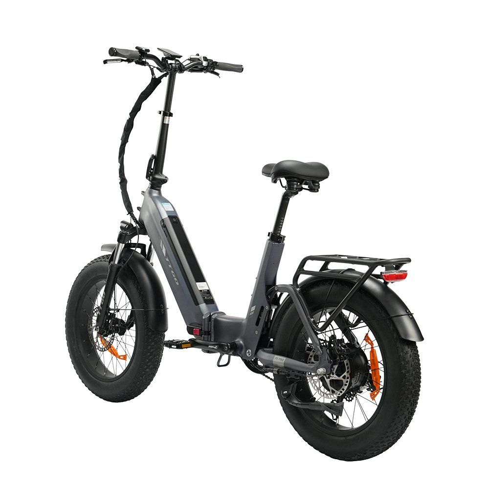 E-bike pieghevole grigia con pneumatici neri e dettagli arancioni. Dotata di portapacchi e freni a disco idraulici.