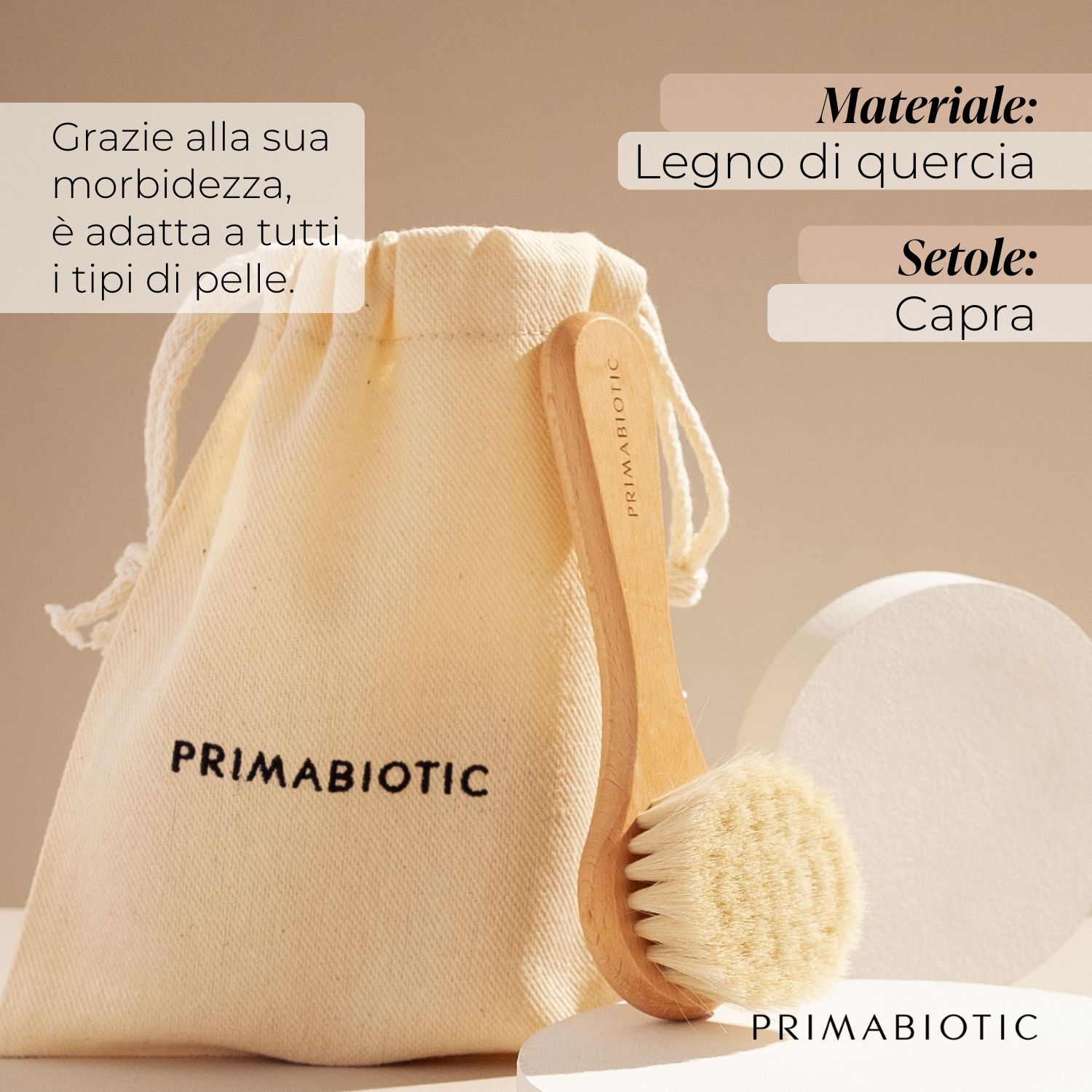 Spazzola per massaggio viso con manico in legno e setole, accanto a un sacchetto. Il sacchetto riporta PRIMABIOTIC. Testo: Materiale: legno di quercia, Setole: capra.