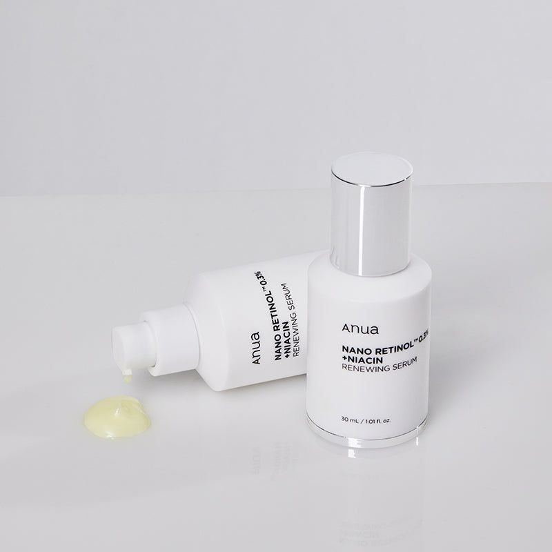 Due flaconi bianchi con tappi argentati. Scritta: Anua, Nano Retinol 0.3% + Niacin Renewing Serum. Liquido giallo accanto.