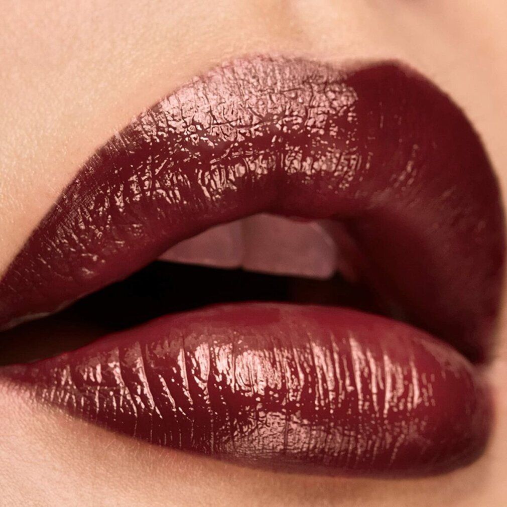 Primo piano di labbra truccate con un rossetto rosso scuro. Le labbra sono lucide e ben definite.