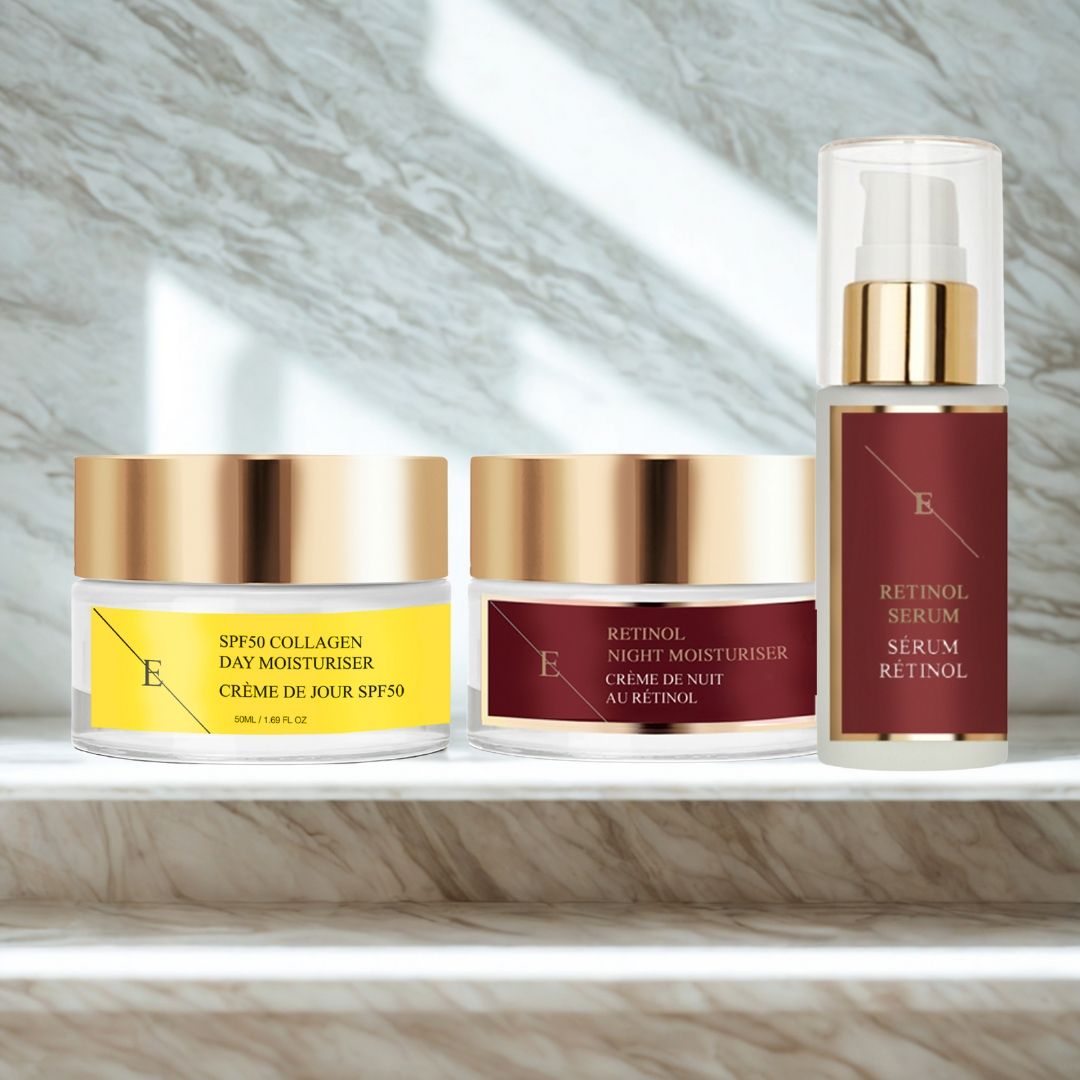 Tre prodotti cosmetici: crema giorno, crema notte e siero. Coperchi dorati, etichette con testo. Scritta: Siero al retinolo, crema giorno SPF50.