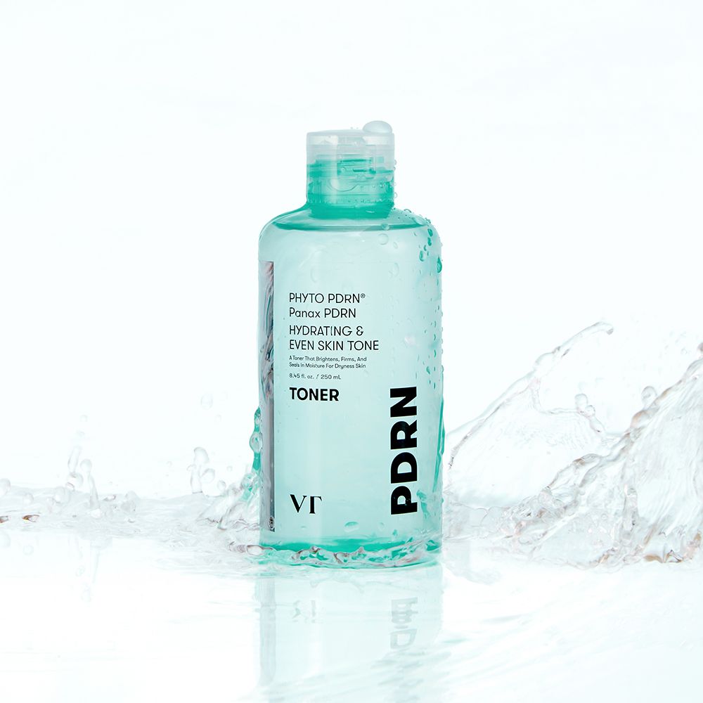 Flacone verde di toner VT COSMETICS PHYTO PDRN. L'acqua schizza intorno al flacone.
