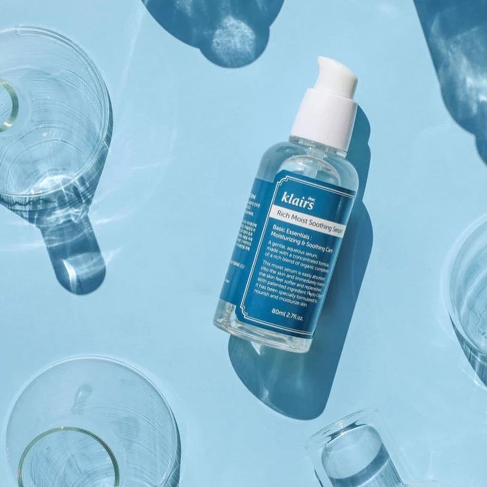 Siero lenitivo Rich Moist di Klairs. Flacone su sfondo blu con contenitori di vetro.