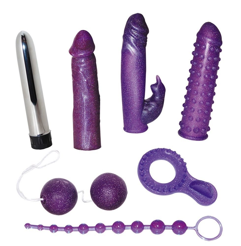 Sette sextoys viola: vibratore, due dildo, un dildo con borchie, due sfere con cordino, un anello con borchie e una collana di perle.
