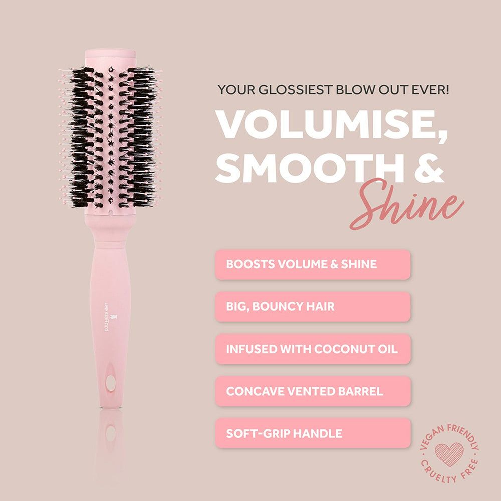 Una spazzola rotonda rosa con setole nere e testo su volume e lucentezza.