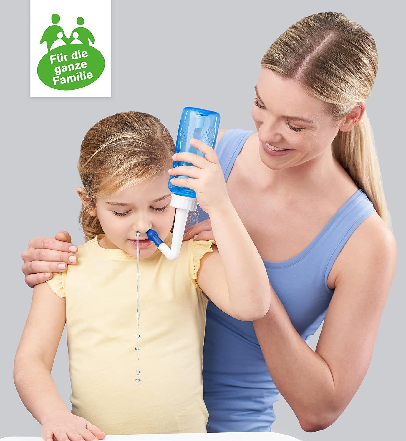 Donna e bambino. Il bambino riceve una doccia nasale. Doccia nasale blu. Logo: Per tutta la famiglia.
