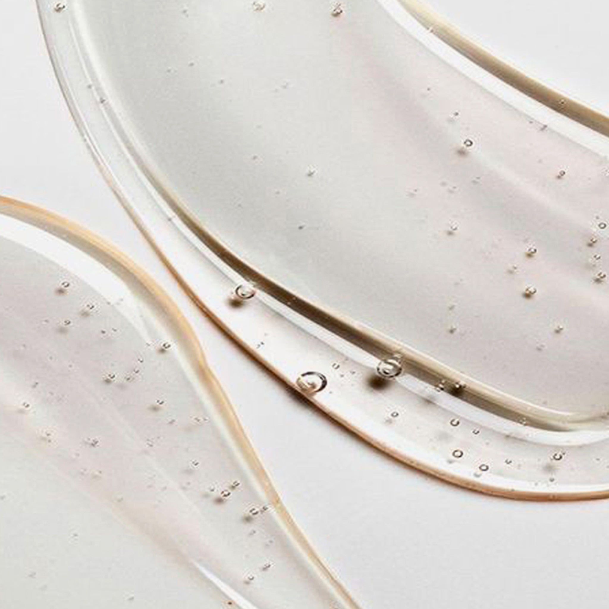 Primo piano di gel shampoo trasparente. Su sfondo chiaro. Bolle visibili.