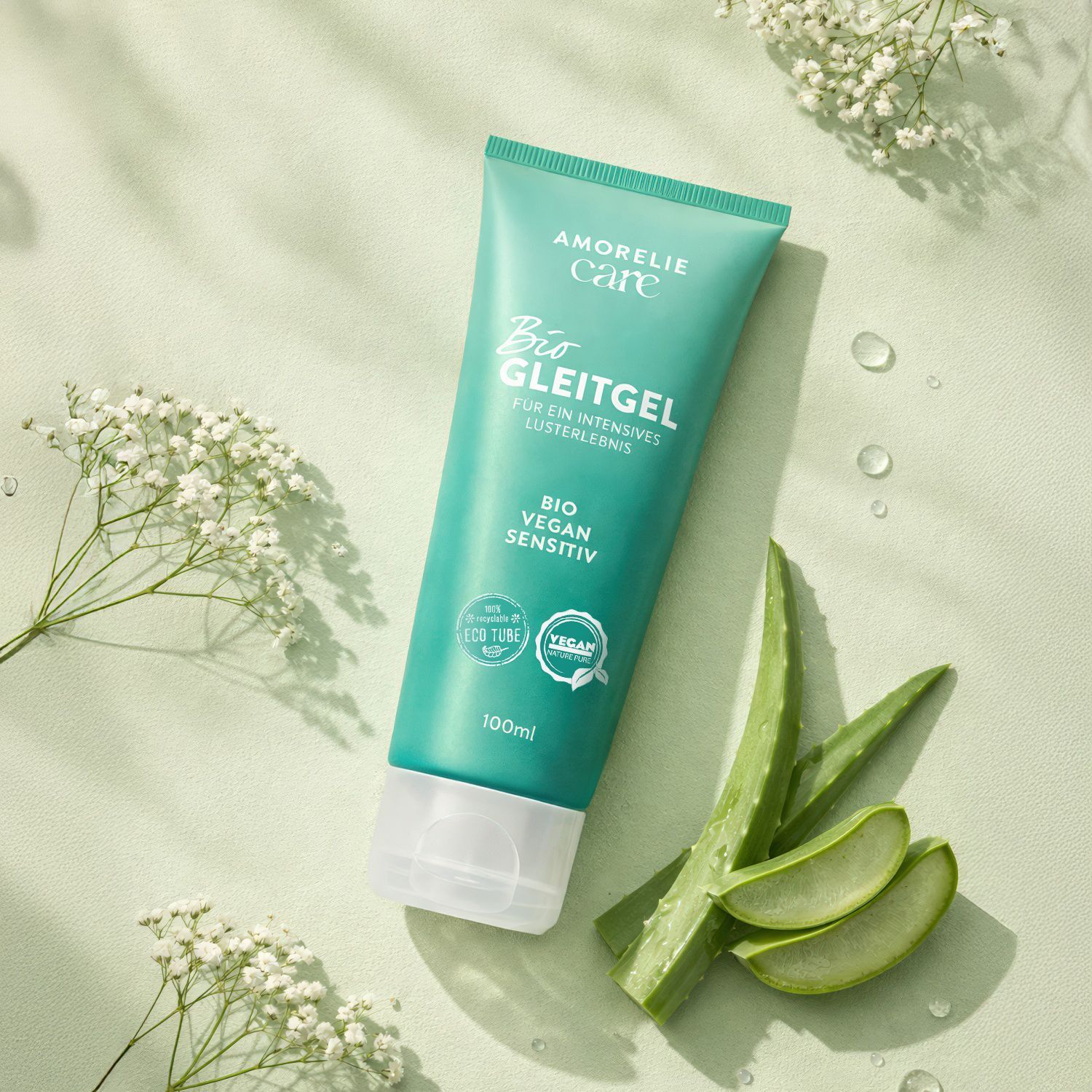 Tubo verde con testo e logo. Accanto al tubo, foglie di aloe vera e fiori.