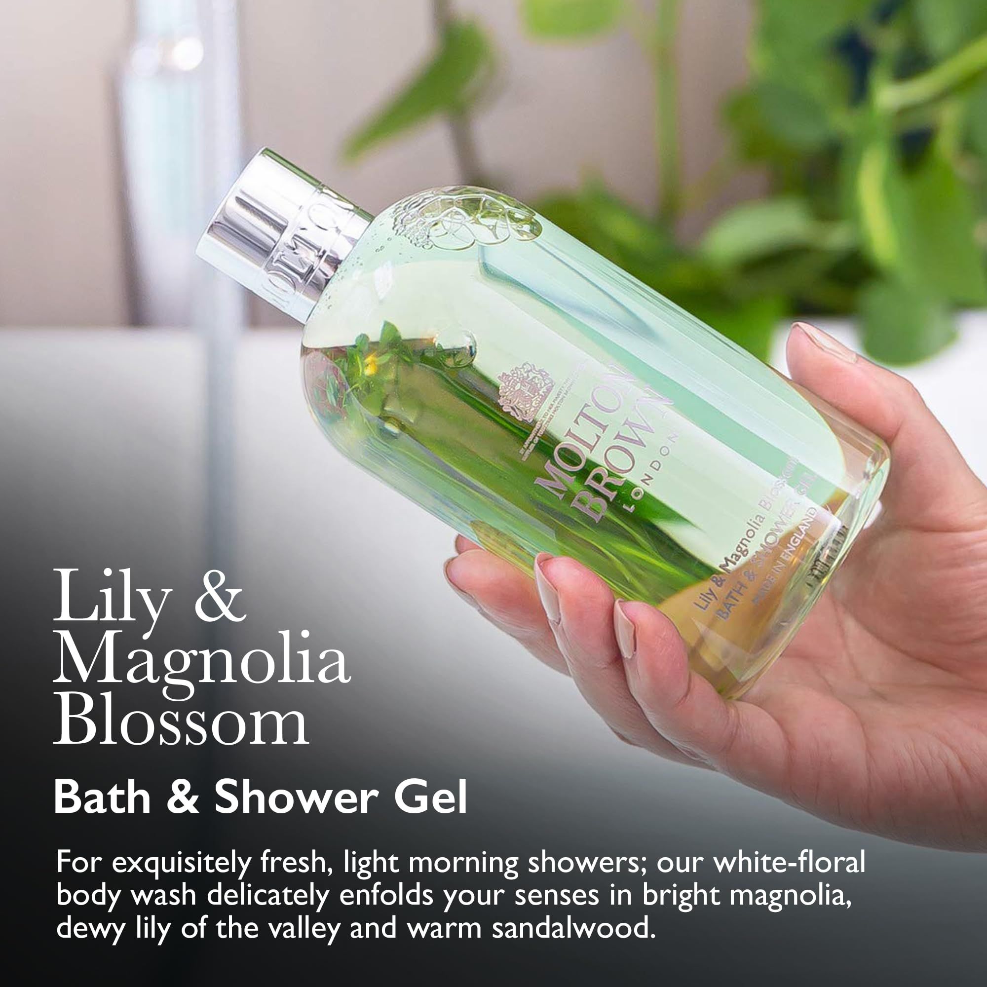 Mano che tiene un flacone verde. Testo: "Lily & Magnolia Blossom Bath & Shower Gel". Marchio: MOLTON BROWN. Sfondo: bagno.