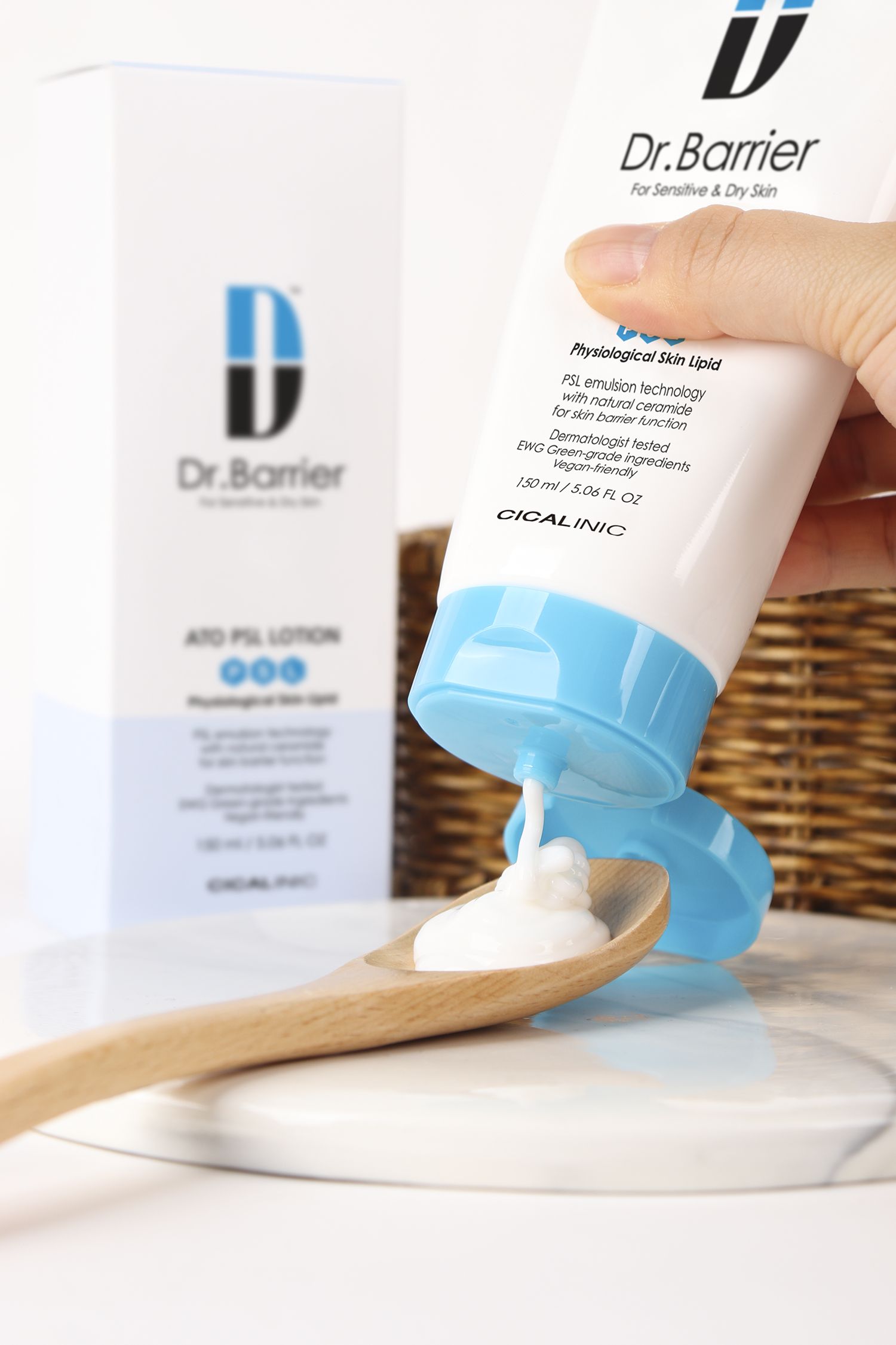 Tubo bianco con tappo blu. Scritta: Dr.Barrier ATO PSL Lotion. Crema versata su un cucchiaio di legno.